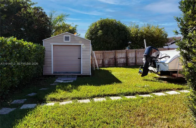 a yellow house with a yard and a large tree