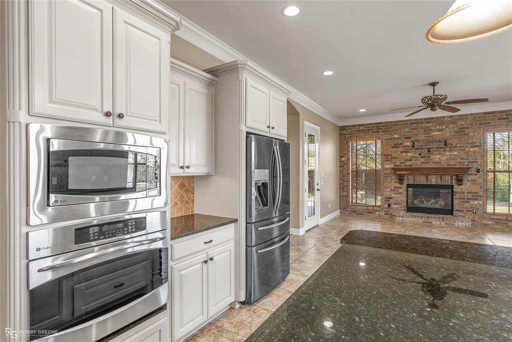 4743 Old Brownlee Road Bossier City, LA 71111 - Photo 23 of 40 a kitchen with stainless steel appliances kitchen island granite countertop a refrigerator oven and a stove