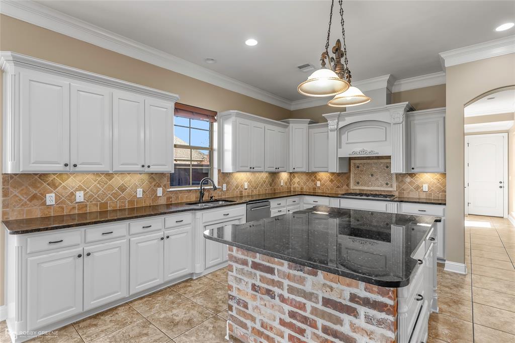 4743 Old Brownlee Road Bossier City, LA 71111 - Photo 24 of 40 a kitchen with granite countertop a stove and white cabinets