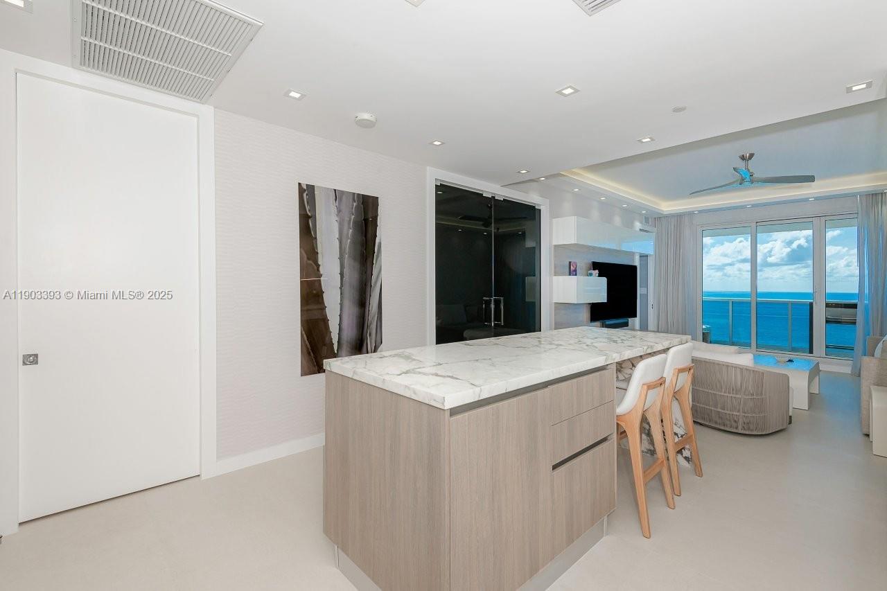 2301 Collins Avenue, Unit PH20 Miami Beach, FL 33139 - Photo 11 of 28 a room with kitchen island and white cabinets