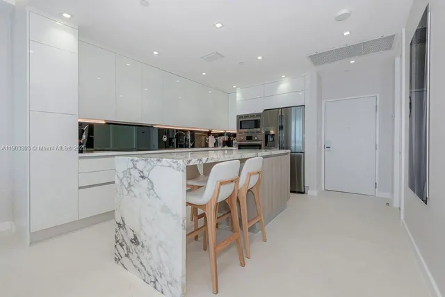 a kitchen with stainless steel appliances a refrigerator sink and microwave