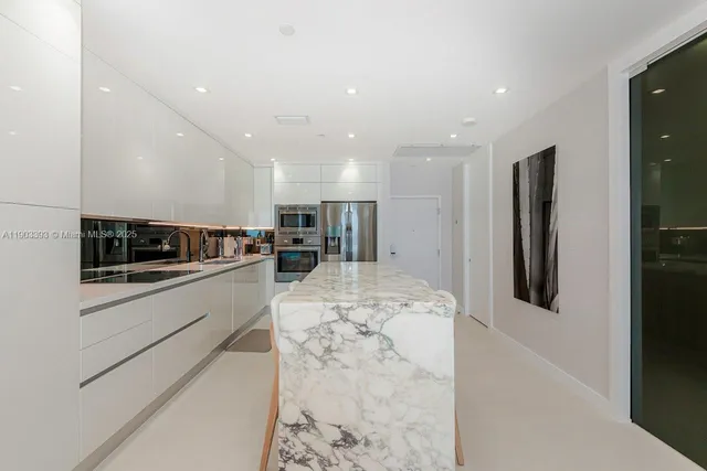 a kitchen with stainless steel appliances kitchen island granite countertop a refrigerator and a stove top oven