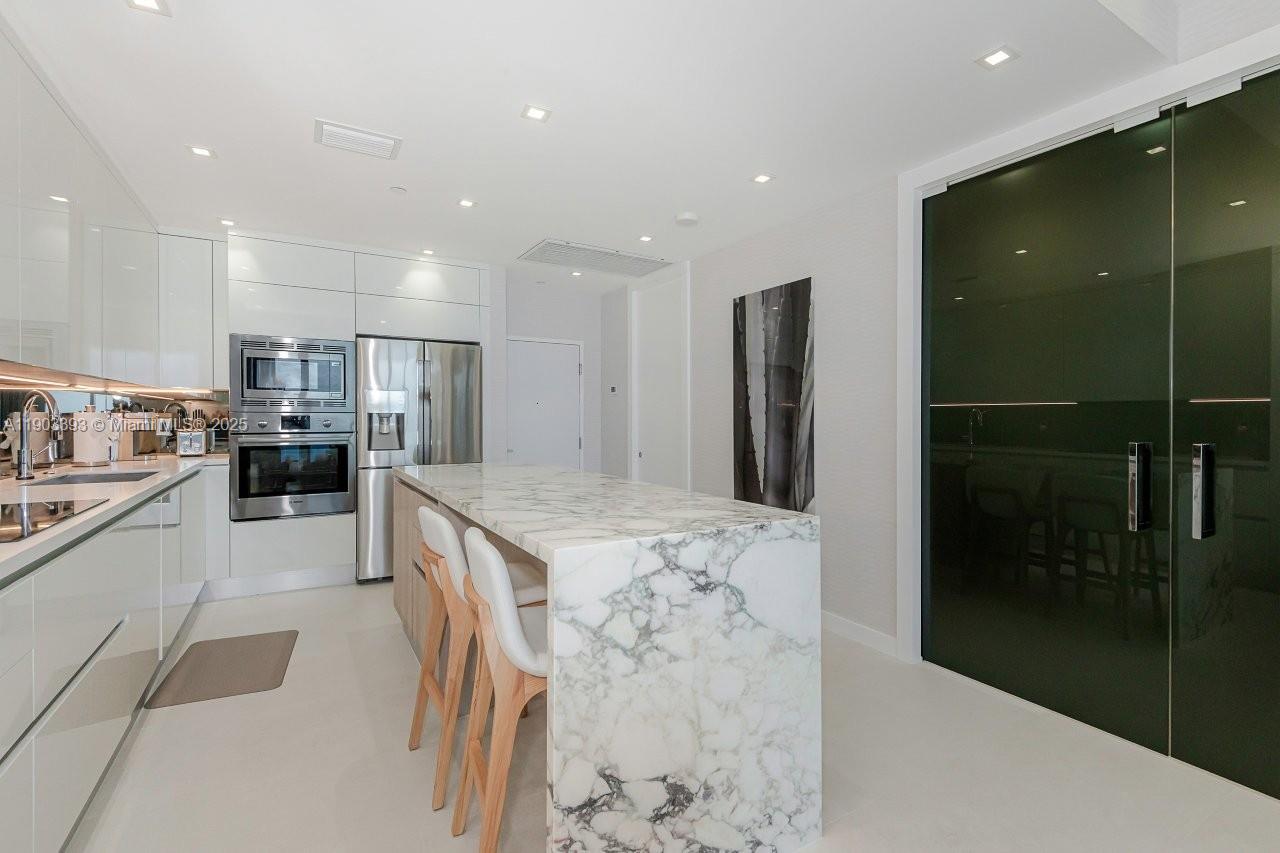 2301 Collins Avenue, Unit PH20 Miami Beach, FL 33139 - Photo 8 of 28 a kitchen with stainless steel appliances kitchen island granite countertop a refrigerator and a sink