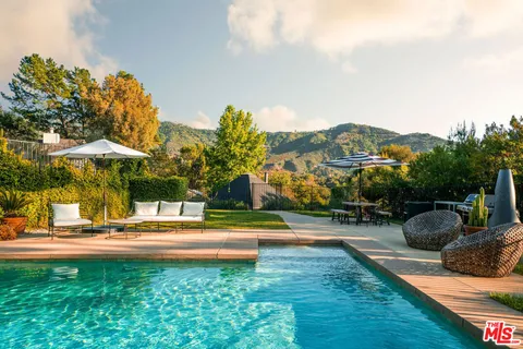 a backyard of a house with table and chairs