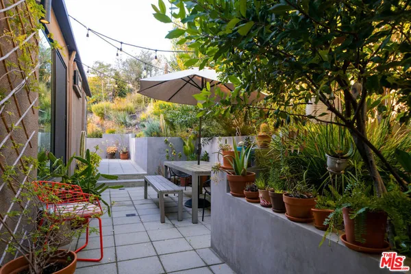 a view of a patio with table and chairs potted plants