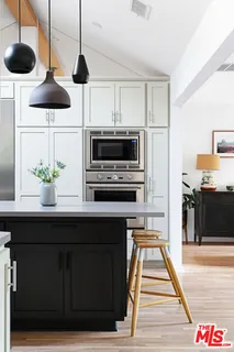 a kitchen with stainless steel appliances a stove a microwave and wooden floor