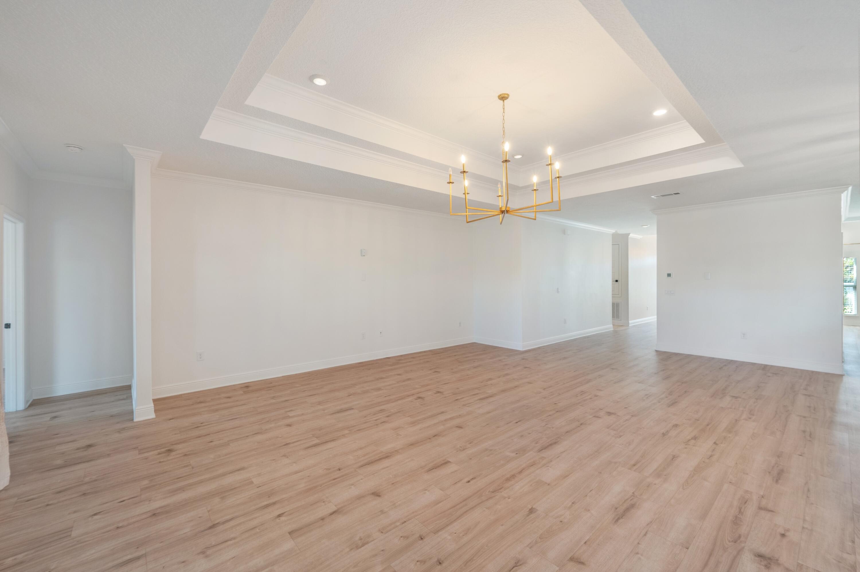 53 Palmer Lane Santa Rosa Beach, FL 32459 - Photo 20 of 62 wooden floor in an empty room with a chandelier