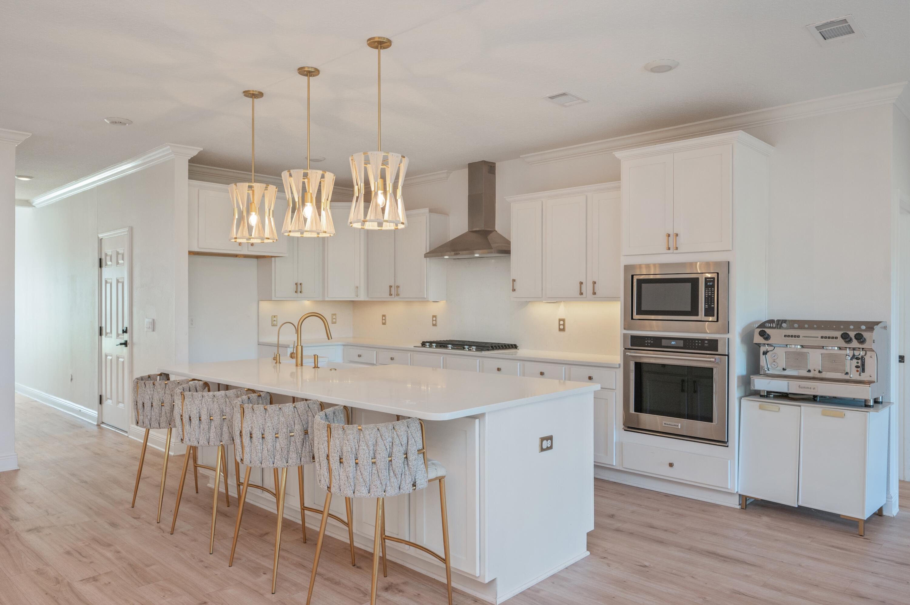 53 Palmer Lane Santa Rosa Beach, FL 32459 - Photo 9 of 62 a kitchen with a center island white cabinets and stainless steel appliances