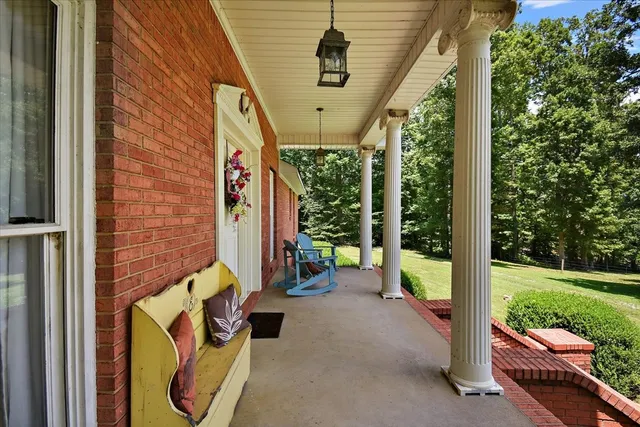 a view of a porch with furniture and garden