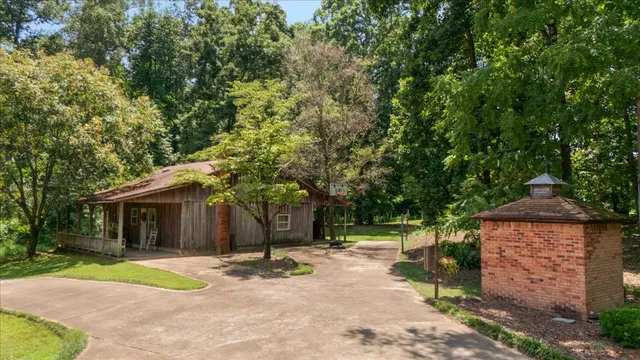 an aerial view of a residential houses with outdoor space and trees