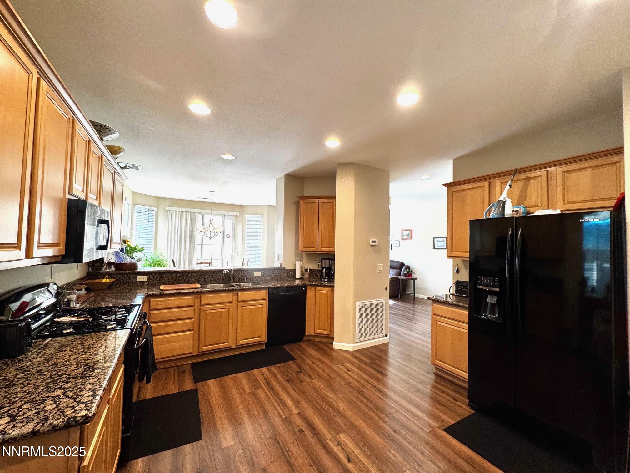11044 Lamour Lane Reno, NV 89521 - Photo 5 of 21 a kitchen with stainless steel appliances granite countertop a refrigerator stove top oven and sink