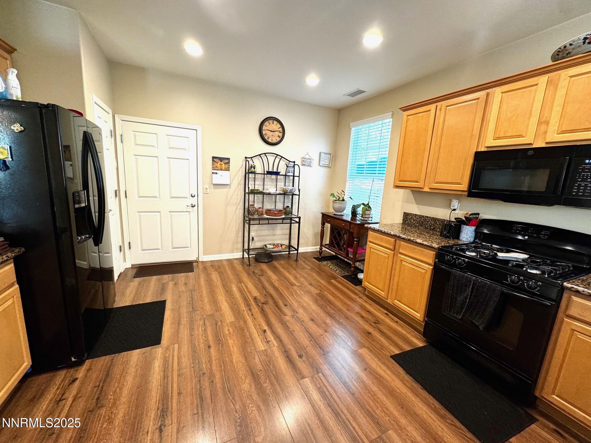 11044 Lamour Lane Reno, NV 89521 - Photo 6 of 21 a kitchen with stainless steel appliances a stove top oven a sink dishwasher and a refrigerator with wooden floor