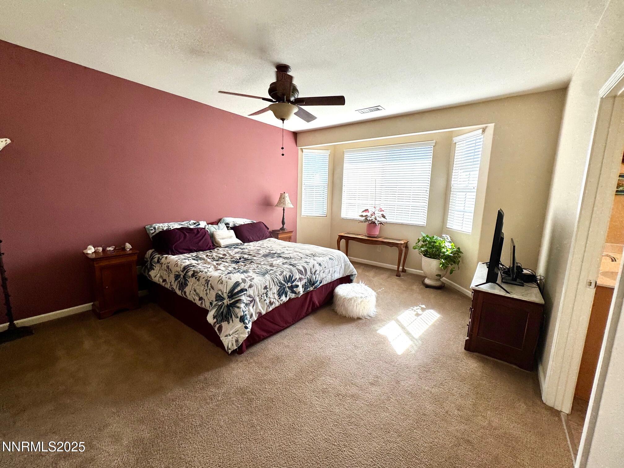 11044 Lamour Lane Reno, NV 89521 - Photo 9 of 21 a bedroom with a bed couch chandelier and a window