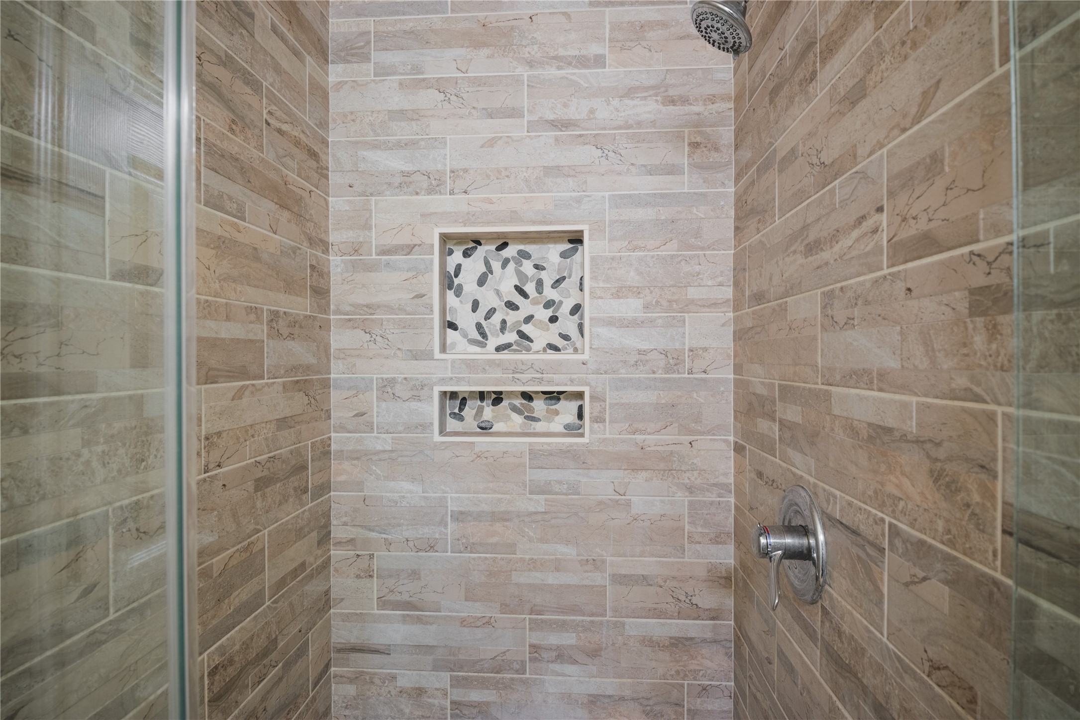 20145 Janak Road Coupland, TX 78615 - Photo 21 of 40 A rejuvenating shower with natural stone accents offers a serene bathing experience.