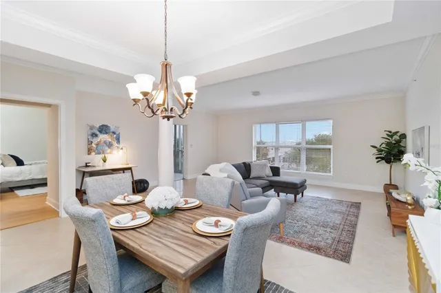 a dining room filled chandelier and kitchen view