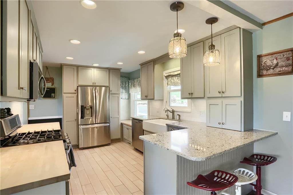 172 Bauder School Road Prospect, PA 16052 - Photo 7 of 25 a kitchen with stainless steel appliances granite countertop a refrigerator a oven a sink and white cabinets
