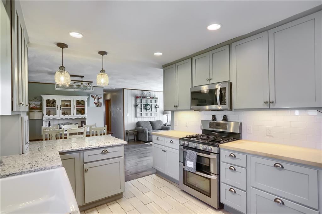 172 Bauder School Road Prospect, PA 16052 - Photo 9 of 25 a kitchen with stainless steel appliances kitchen island granite countertop a sink stove and cabinets