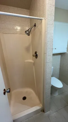 a white toilet sitting next to a bath tub