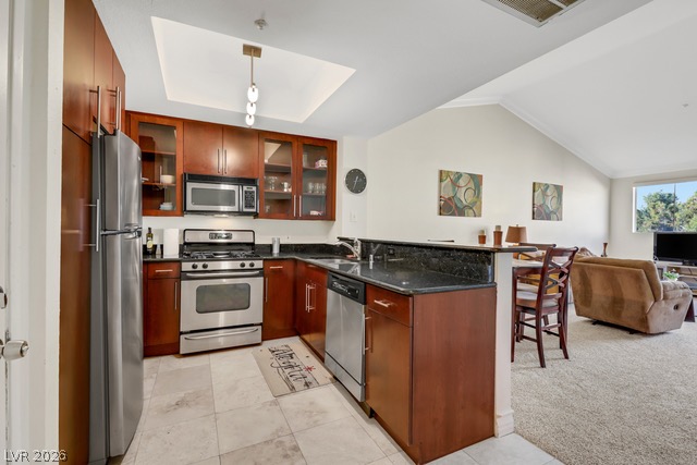230 East Flamingo Road, Unit 435 Las Vegas, NV 89169 - Photo 4 of 15 An open concept kitchen features stainless steel appliances, granite countertops, and rich wood cabinetry, flowing into a comfortable living area.