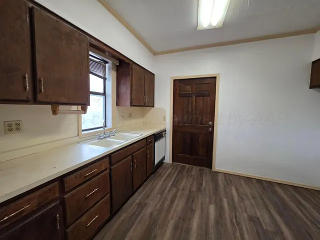a kitchen with wooden floors and wooden cabinets