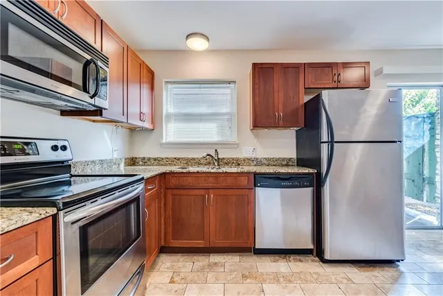 a kitchen with stainless steel appliances granite countertop a refrigerator stove a sink and dishwasher