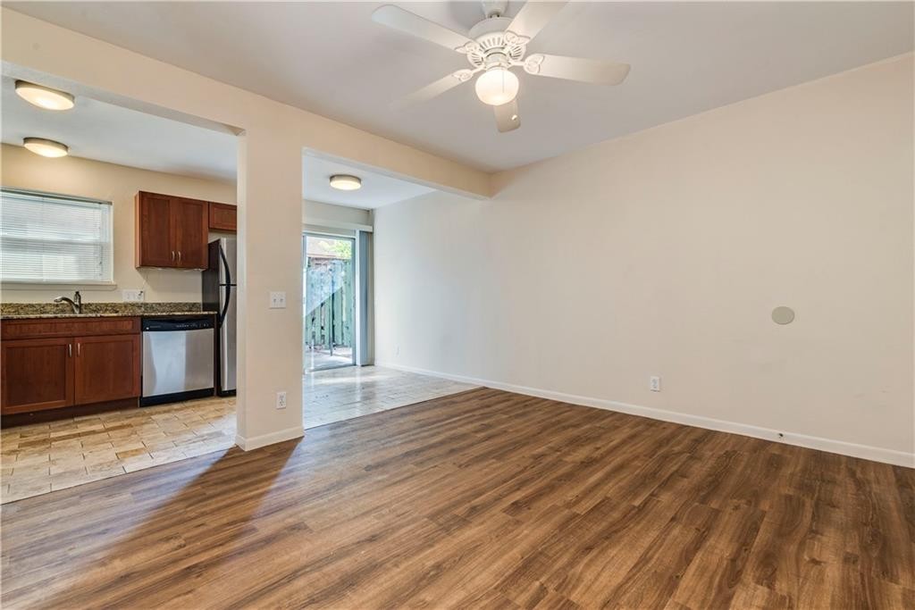 2800 Cole Street, Unit 107C Austin, TX 78705 - Photo 4 of 13 an empty room with wooden floor kitchen view and a window