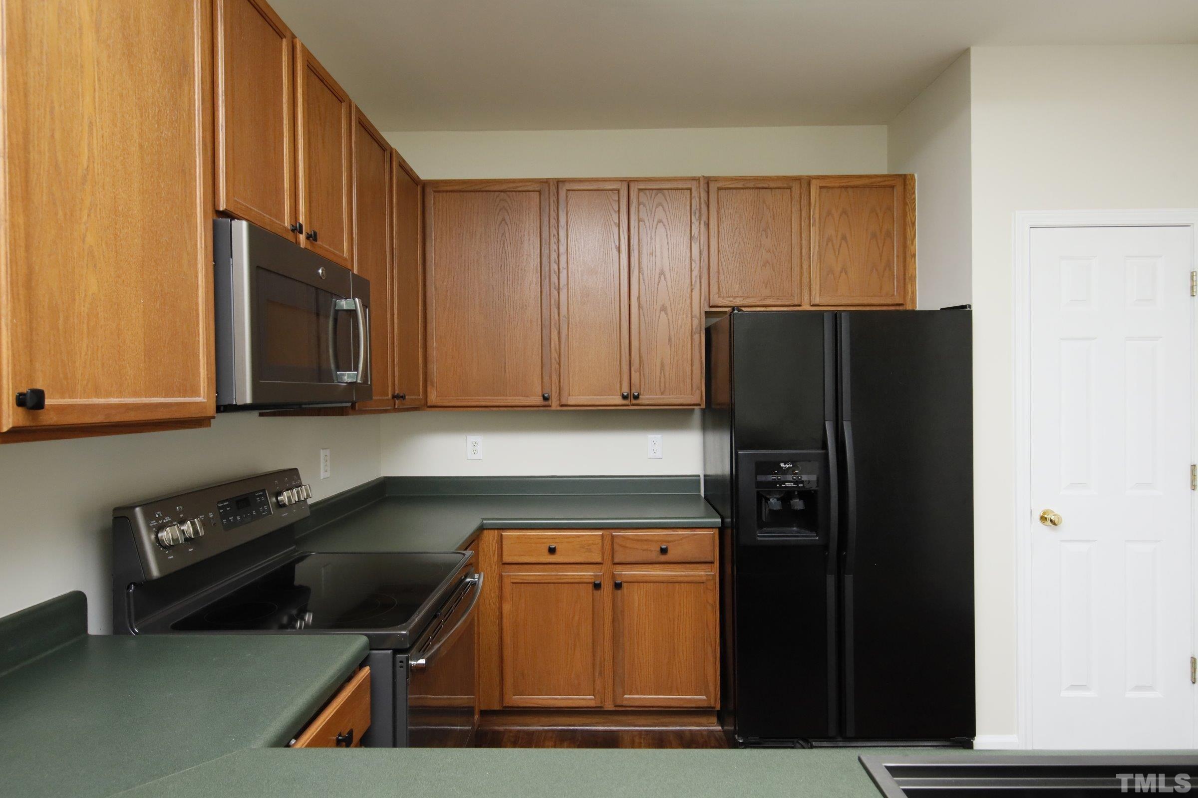 5633 Slide Rock Lane Raleigh, NC 27613 - Photo 11 of 32 a kitchen with a refrigerator and a stove