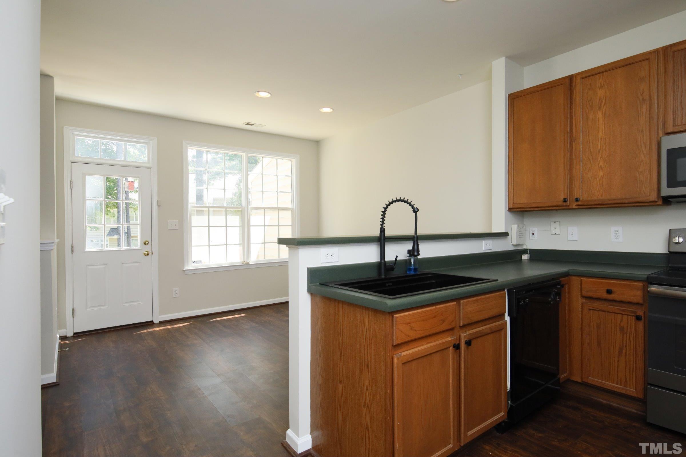 5633 Slide Rock Lane Raleigh, NC 27613 - Photo 12 of 32 a kitchen with stainless steel appliances granite countertop a sink a stove cabinets and wooden floor