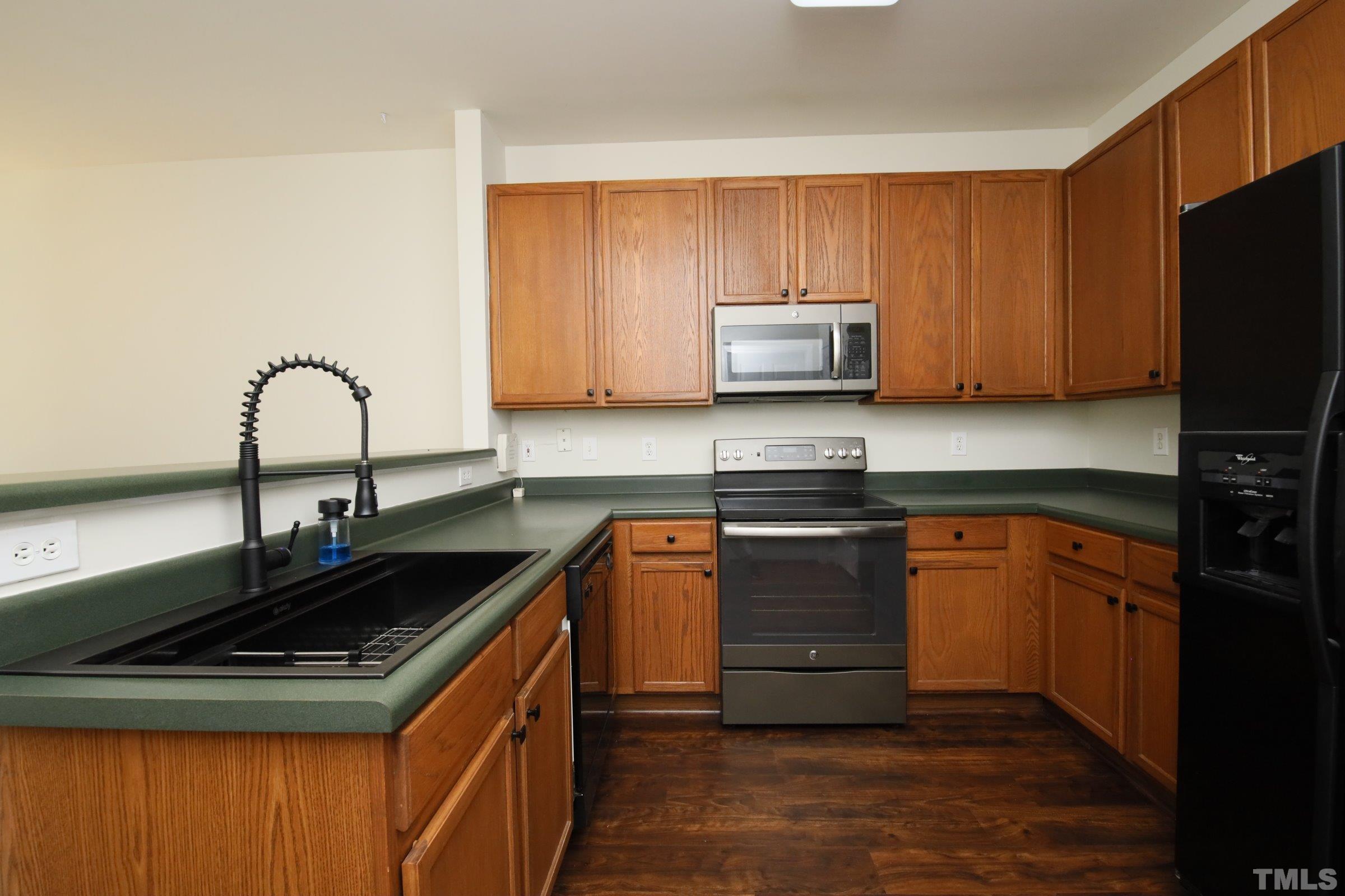 5633 Slide Rock Lane Raleigh, NC 27613 - Photo 15 of 32 a kitchen with granite countertop a sink stove and microwave