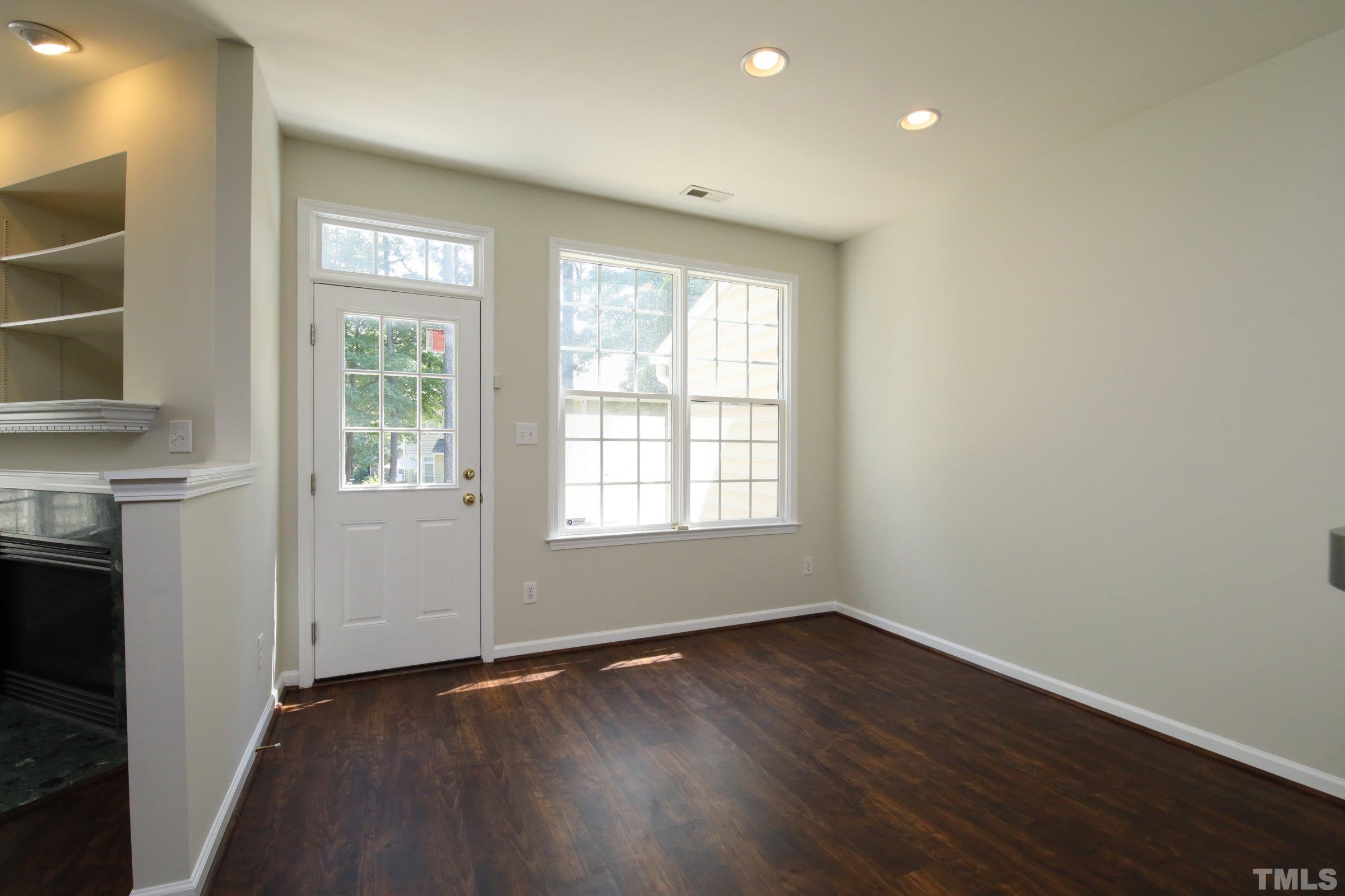 5633 Slide Rock Lane Raleigh, NC 27613 - Photo 9 of 32 an empty room with wooden floor and windows