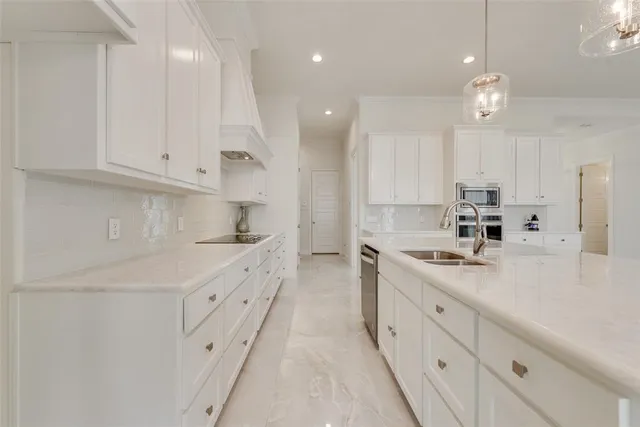 a kitchen with white cabinets sink and stove