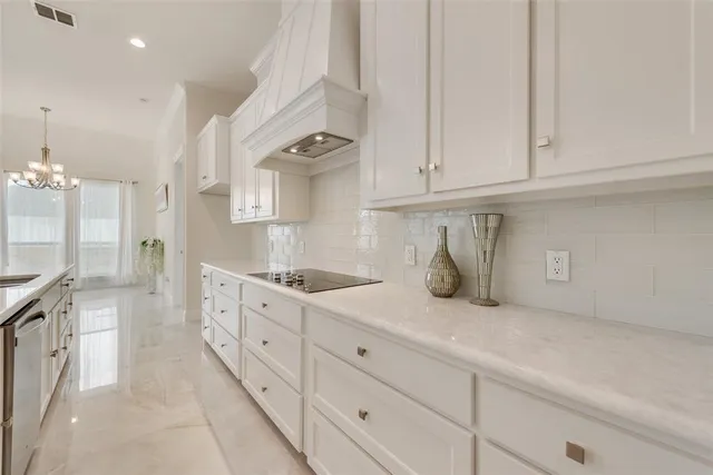 a kitchen with granite countertop white cabinets and stainless steel appliances