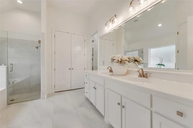 a bathroom with a double vanity sink mirror and shower