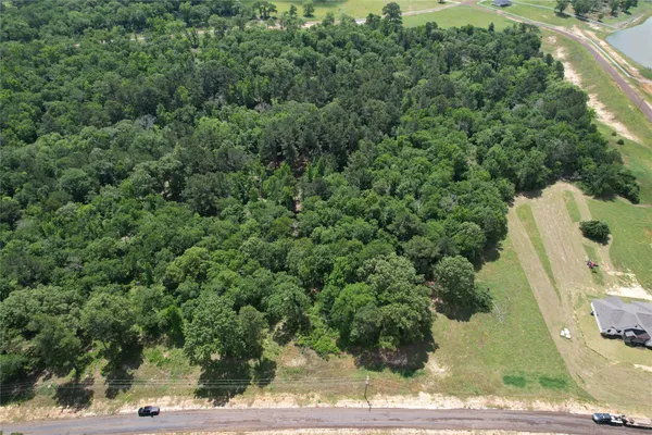 an aerial view of a house with a yard and trees