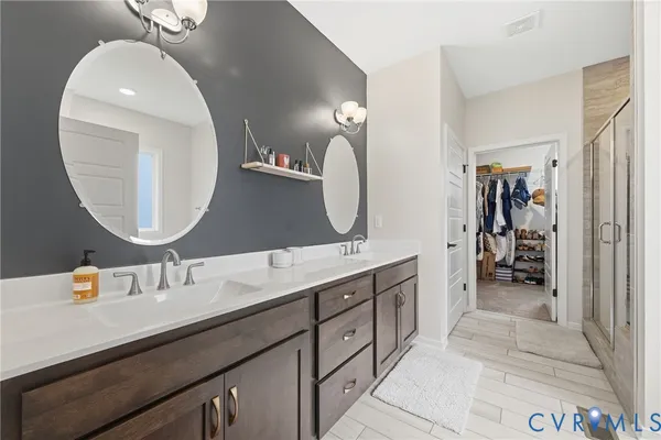 a en suite bathroom with a double vanity sink and a mirror
