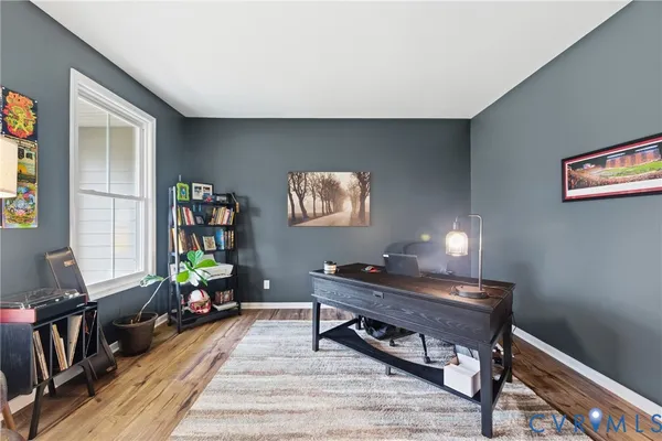a living room with furniture a piano and a bookshelf