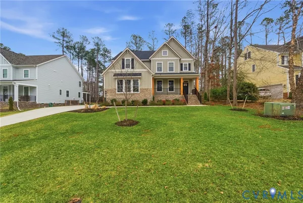 a front view of a house with a garden and trees