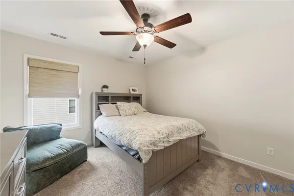 a bedroom with a bed couch and window