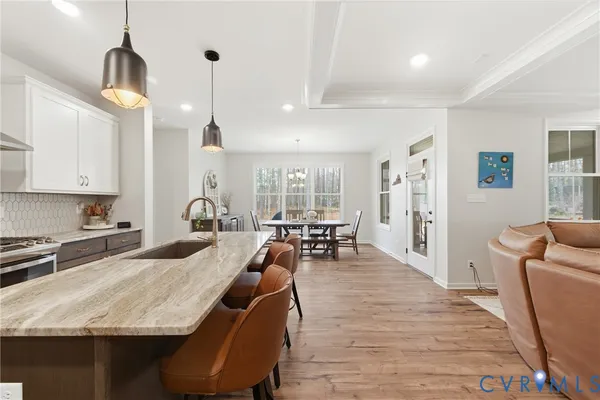 a large kitchen with kitchen island a stove a sink a table and chairs