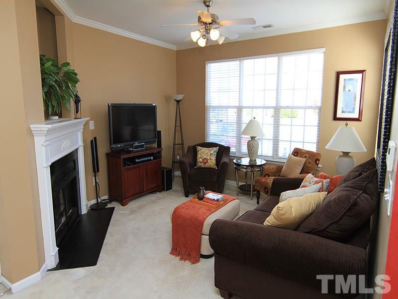 8449 Reedy Ridge Lane Raleigh, NC 27613 - Photo 2 of 12 a living room with furniture a fireplace and a flat screen tv