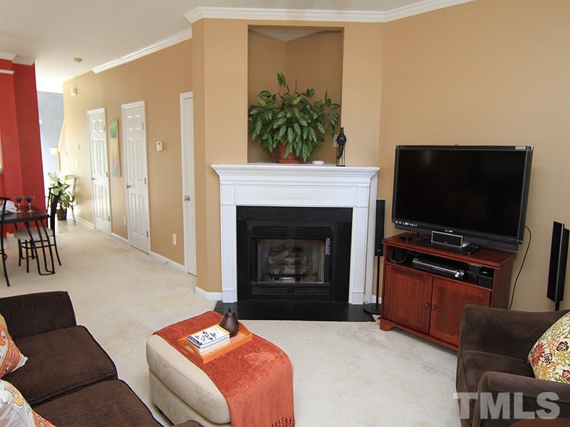 8449 Reedy Ridge Lane Raleigh, NC 27613 - Photo 3 of 12 a living room with furniture a flat screen tv and a fireplace