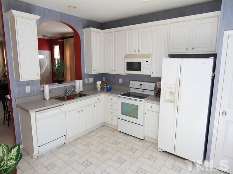 8449 Reedy Ridge Lane Raleigh, NC 27613 - Photo 5 of 12 a kitchen with white cabinets and white appliances