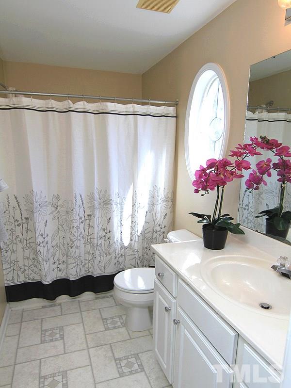 8449 Reedy Ridge Lane Raleigh, NC 27613 - Photo 8 of 12 a bathroom with a sink toilet mirror and shower