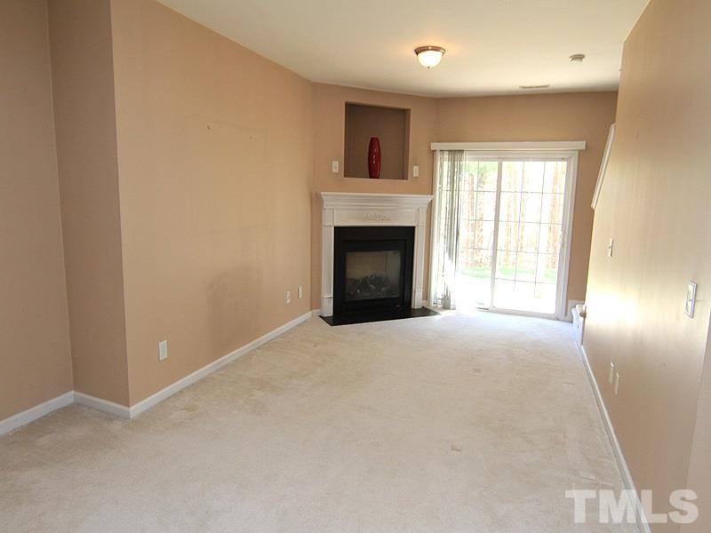 8449 Reedy Ridge Lane Raleigh, NC 27613 - Photo 10 of 12 en empty room with a fireplace and windows