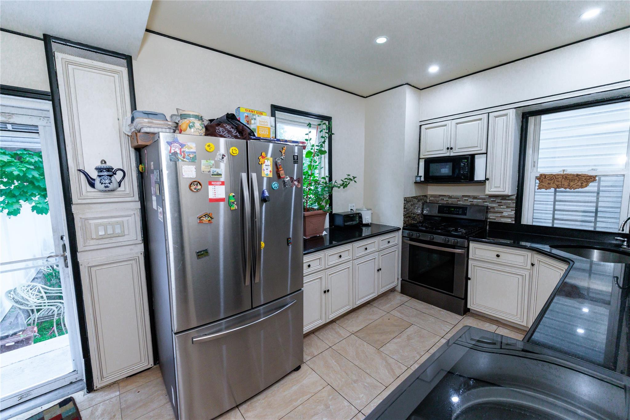 85-21 80th Street Queens, NY 11421 - Photo 12 of 39 a kitchen with stainless steel appliances granite countertop a refrigerator and a stove top oven