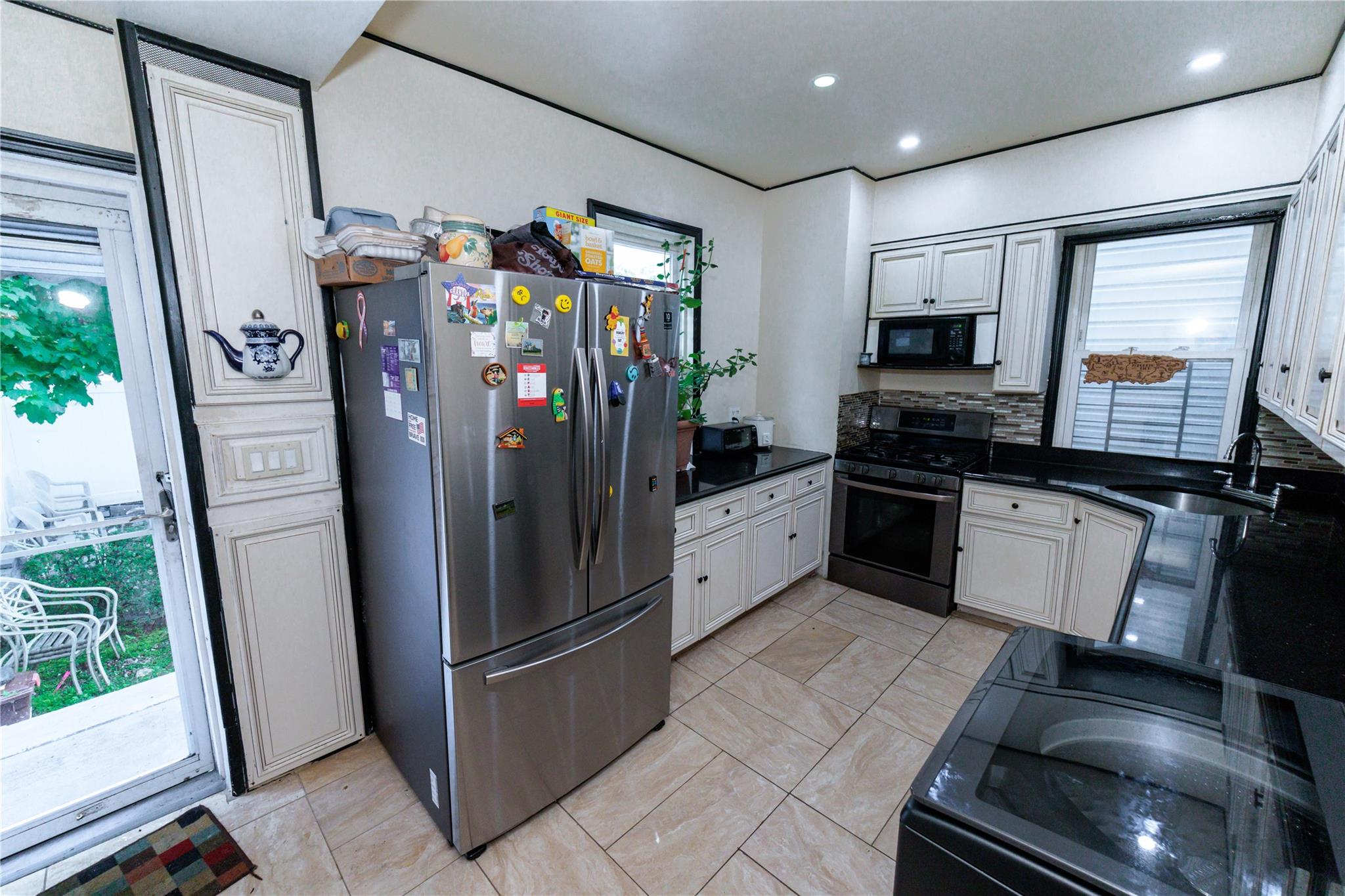 85-21 80th Street Queens, NY 11421 - Photo 13 of 39 a kitchen with stainless steel appliances granite countertop a refrigerator and a sink