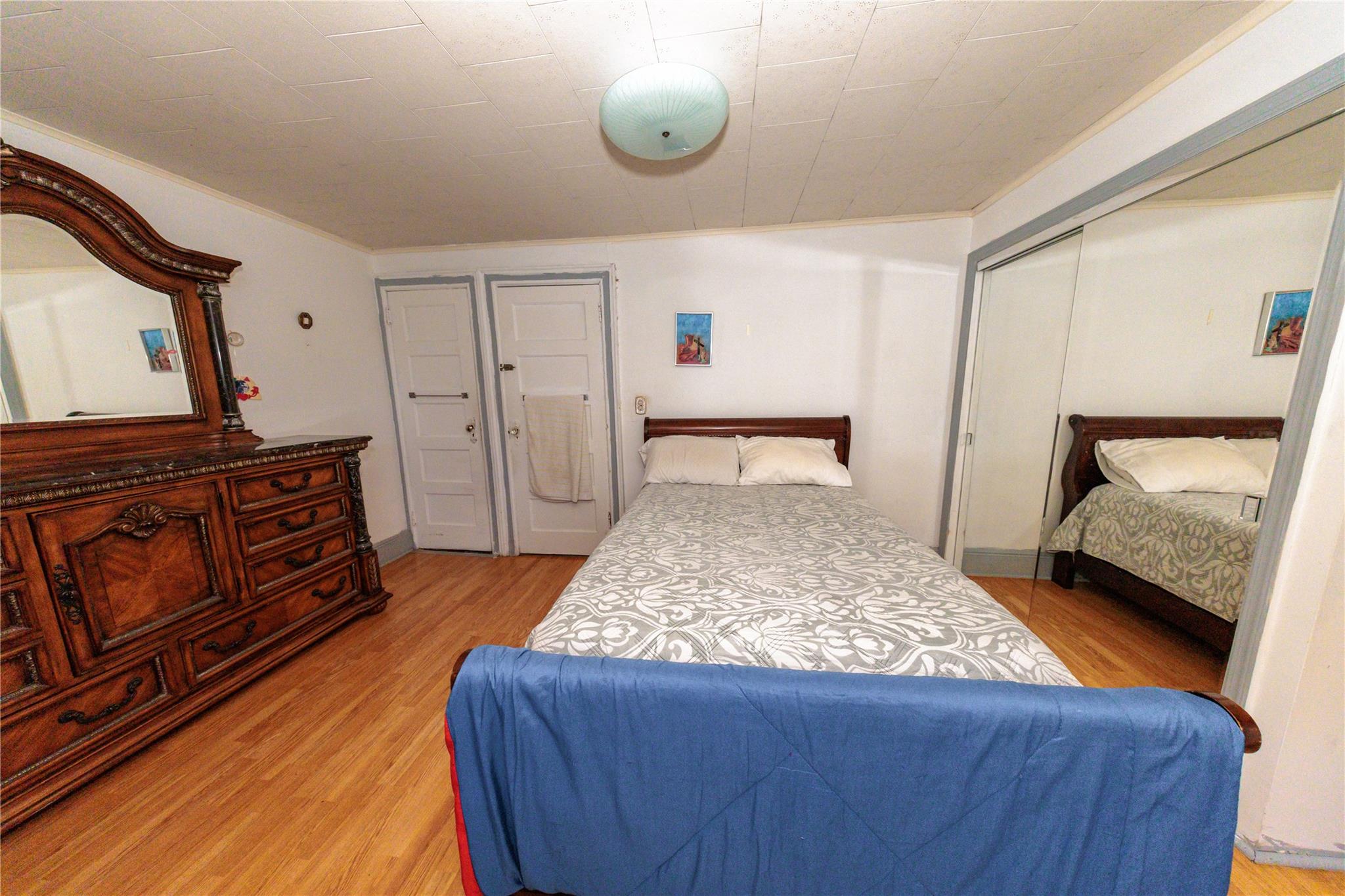 85-21 80th Street Queens, NY 11421 - Photo 20 of 39 a bedroom with a bed and wooden floor