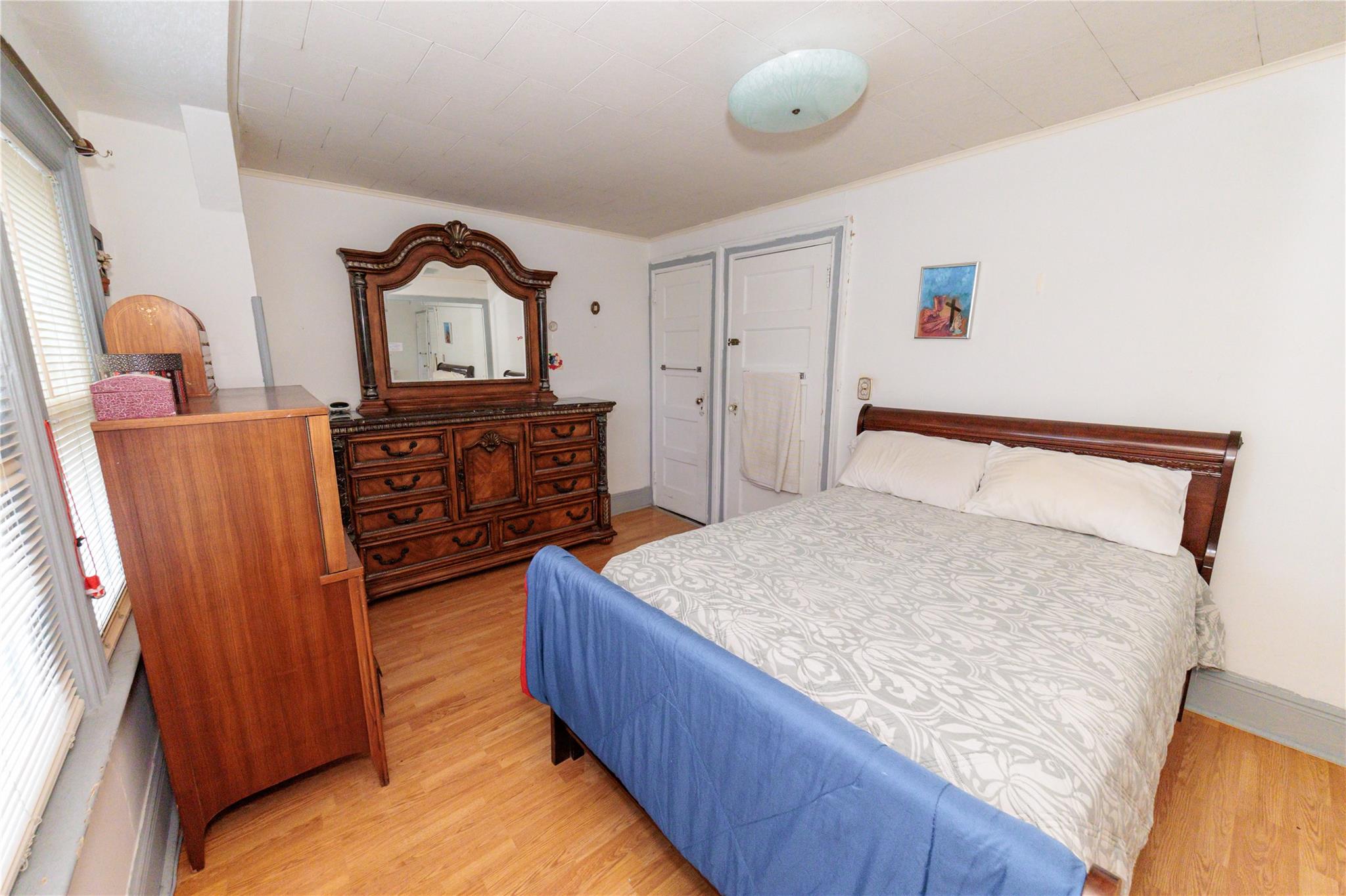 85-21 80th Street Queens, NY 11421 - Photo 21 of 39 a bedroom with a bed and dresser with mirror