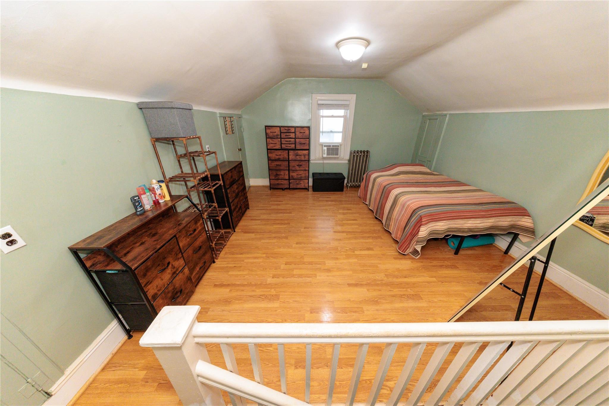 85-21 80th Street Queens, NY 11421 - Photo 26 of 39 a bedroom with a bed and wooden floor