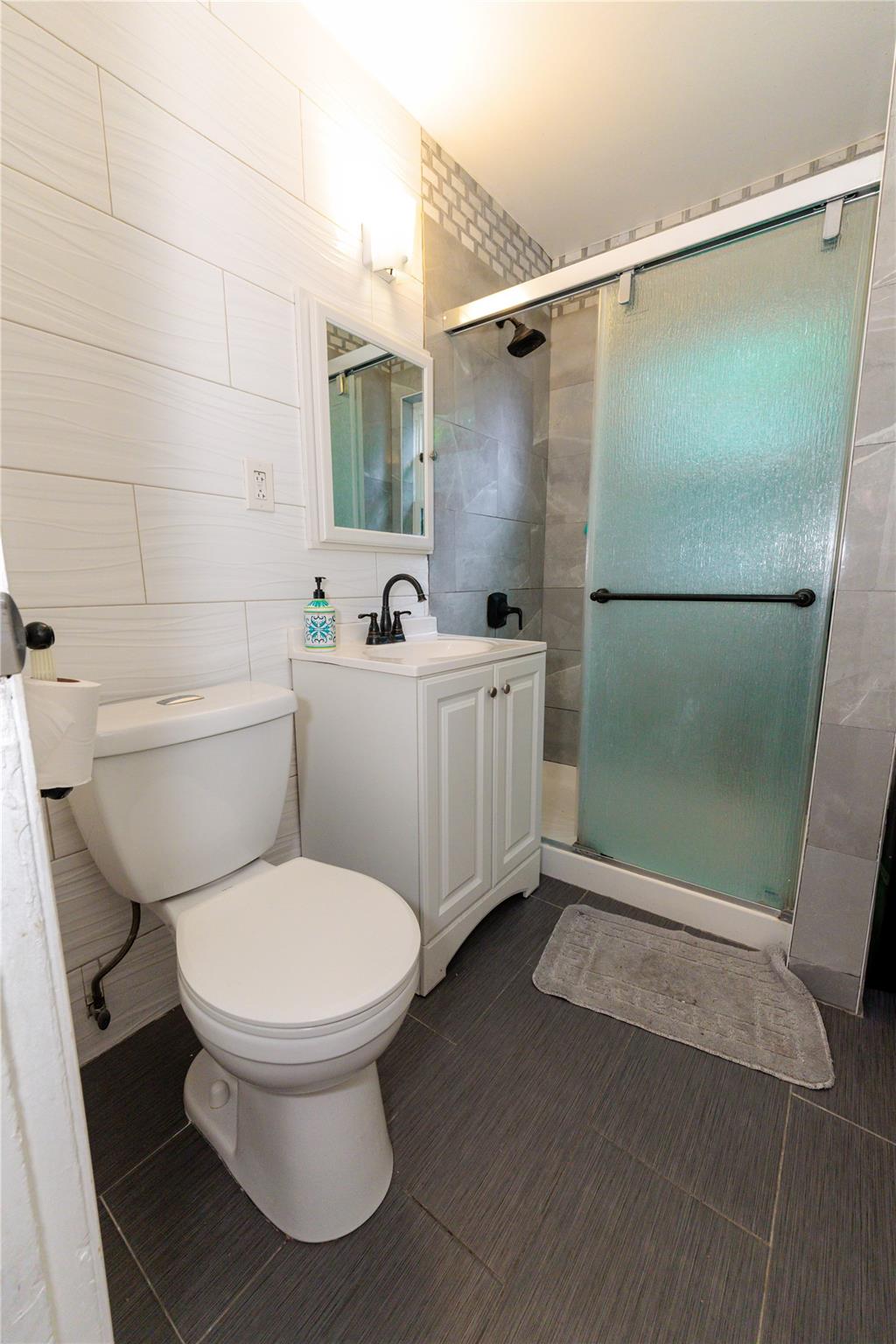 85-21 80th Street Queens, NY 11421 - Photo 27 of 39 a bathroom with a toilet and a shower